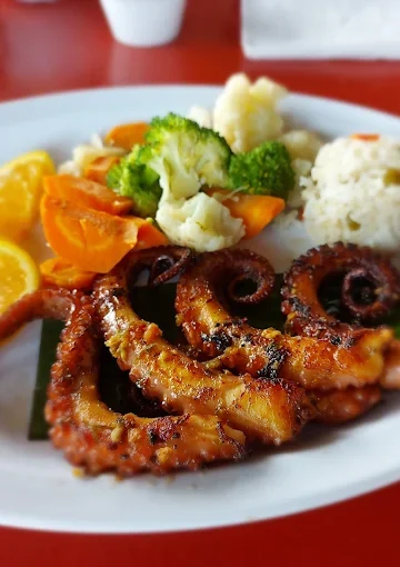 Grilled octopus dinner at Restaurant Villa Ortegas, served with rice and mixed vegetables.