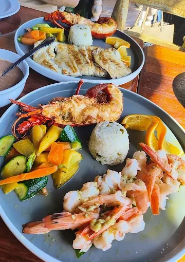 Savor a delectable seafood lunch at Villa Ortegas with grilled fish, shrimp, and fresh vegetables. Discover the perfect blend of flavors in a tropical setting.