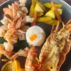 Seafood lunch plate at Restaurant Villa Ortegas with lobster, shrimp, rice, and vegetables.